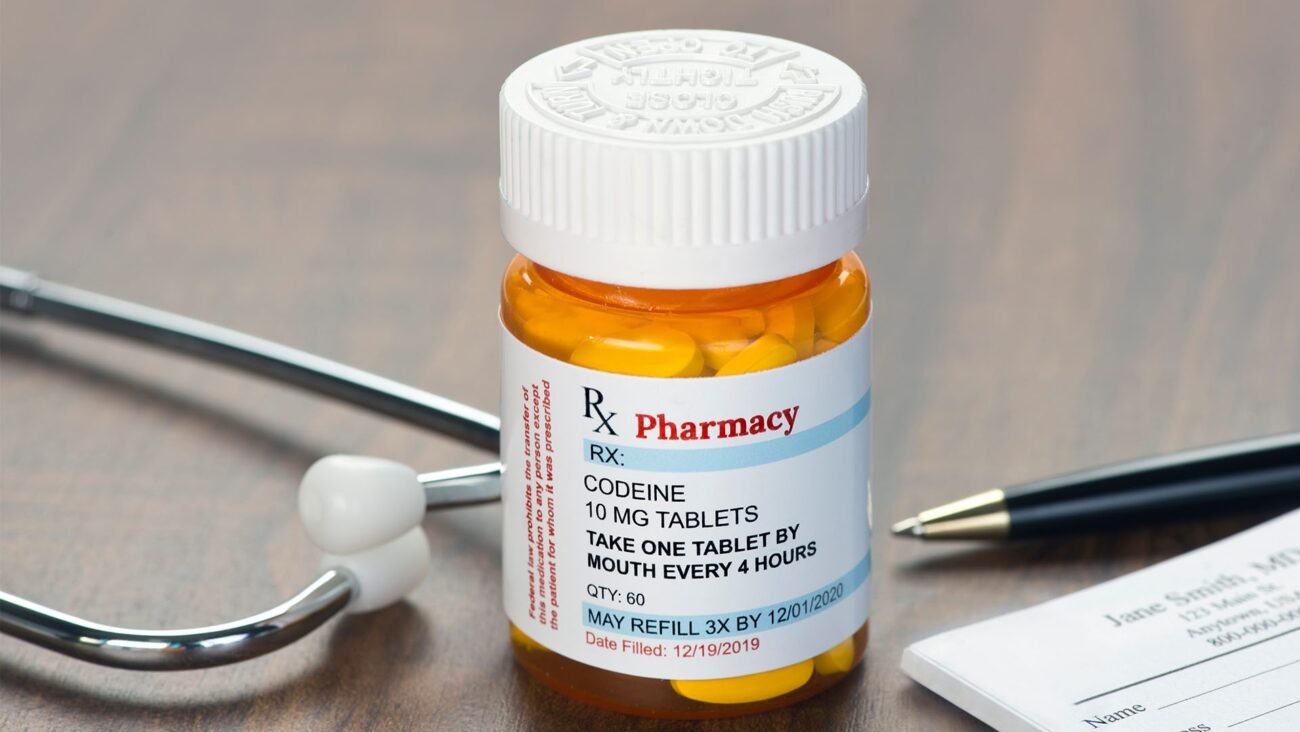 Prescription bottle showing codeine formulation on a professional clinical workspace table