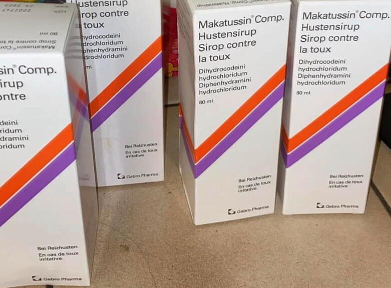A genuine bottle of imported Makatussin syrup containing codeine and antihistamine next to organic Cali grass flowers