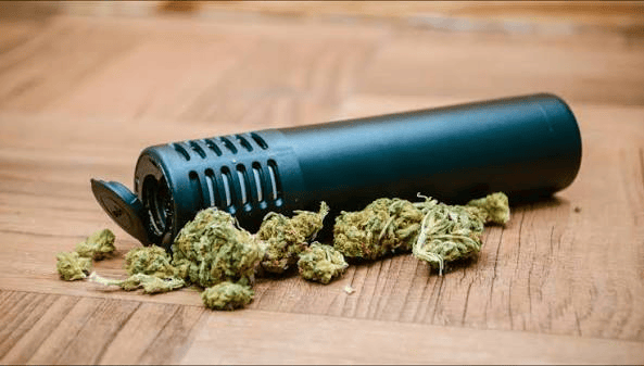 Premium style thc vapes uk vaporizing device held against a blurred city background
