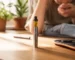 Premium rechargeable thc vape pen lying next to organic botanical terpenes on a wooden background from Prime THC Supply